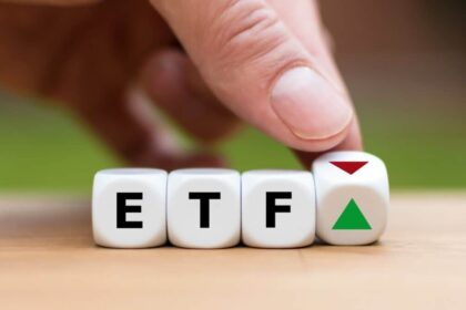 Hand is turning a dice and changes the direction of an arrow symbolizing that the value of an ETF (Exchange Traded Fund) is going up (or vice versa)