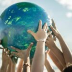 Close-up of children holding a planet at the beach