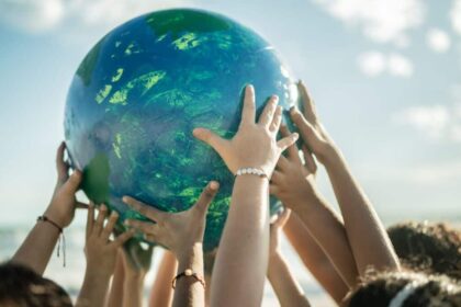 Close-up of children holding a planet at the beach