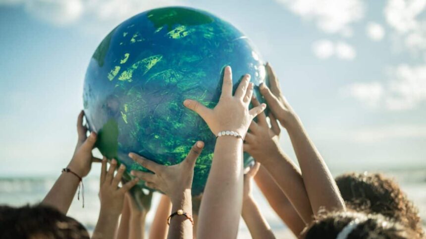 Close-up of children holding a planet at the beach