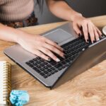 A freelancer working from home, sitting at a desk, using a laptop.