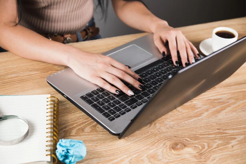 A freelancer working from home, sitting at a desk, using a laptop.