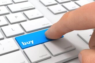 Finger clicking a button marked 'Buy' on a keyboard