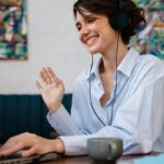 A woman working remotely from home, using a laptop to take video calls.