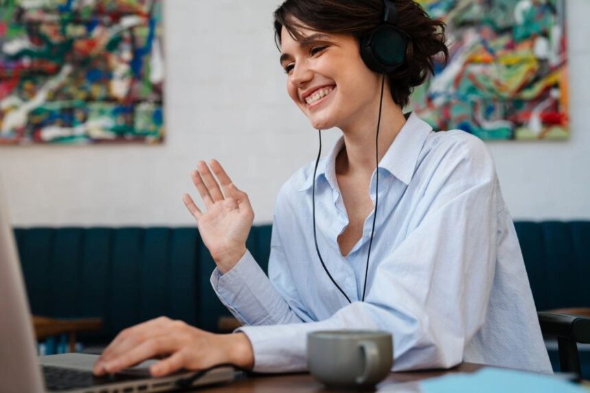 A woman working remotely from home, using a laptop to take video calls.