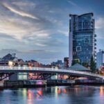 Belfast City Sunset with colorful twilight over Lagan Weir Pedestrian and Cycle Bridge spanning over the Lagan River in downtown Belfast