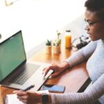 A woman working on her laptop in a cafe.