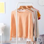 A clothing rack, featuring an assortment of trendy women's clothes.